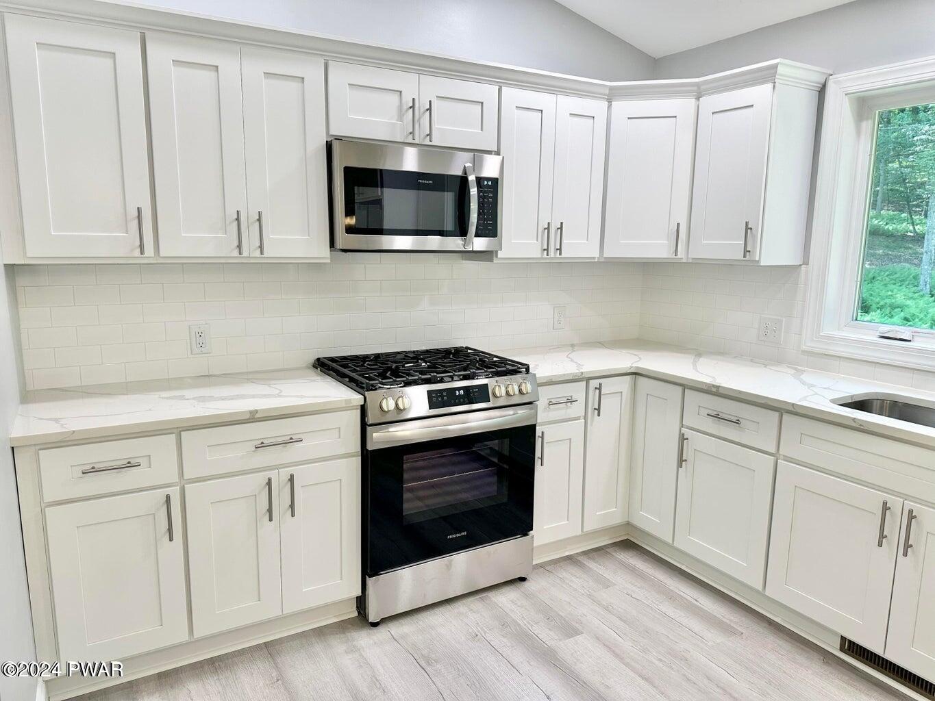 123 R Rhododendron Lane Milford, PA 18337 - Photo 11 of 29 a kitchen with white cabinets stainless steel appliances and sink