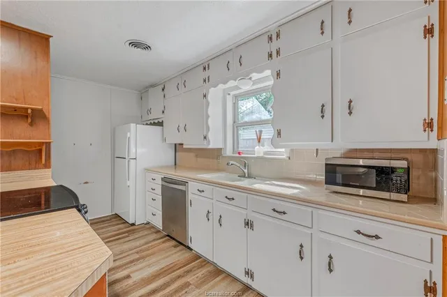 a kitchen with white cabinets and white appliances