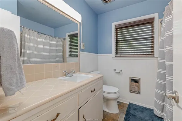 a bathroom with a sink a toilet and a window