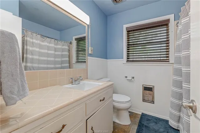 a bathroom with a sink a toilet and a window