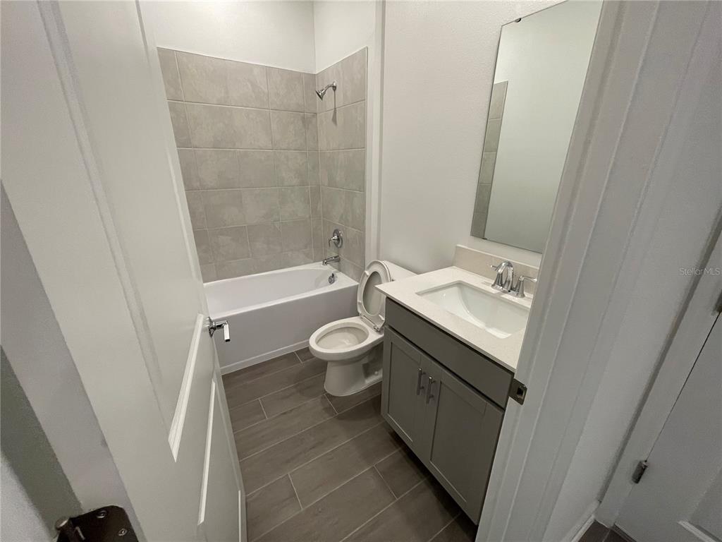 2623 Runners Circle Clermont, FL 34714 - Photo 13 of 21 a bathroom with a granite countertop sink toilet and shower