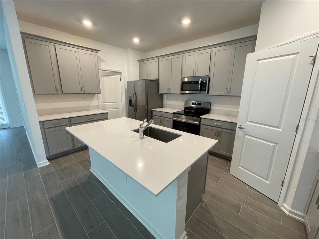 2623 Runners Circle Clermont, FL 34714 - Photo 10 of 21 a kitchen with a refrigerator a sink and a stove top oven