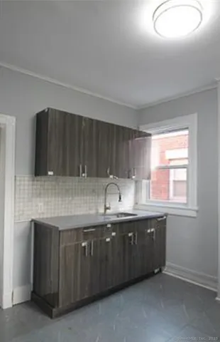 a kitchen with granite countertop a sink and cabinets