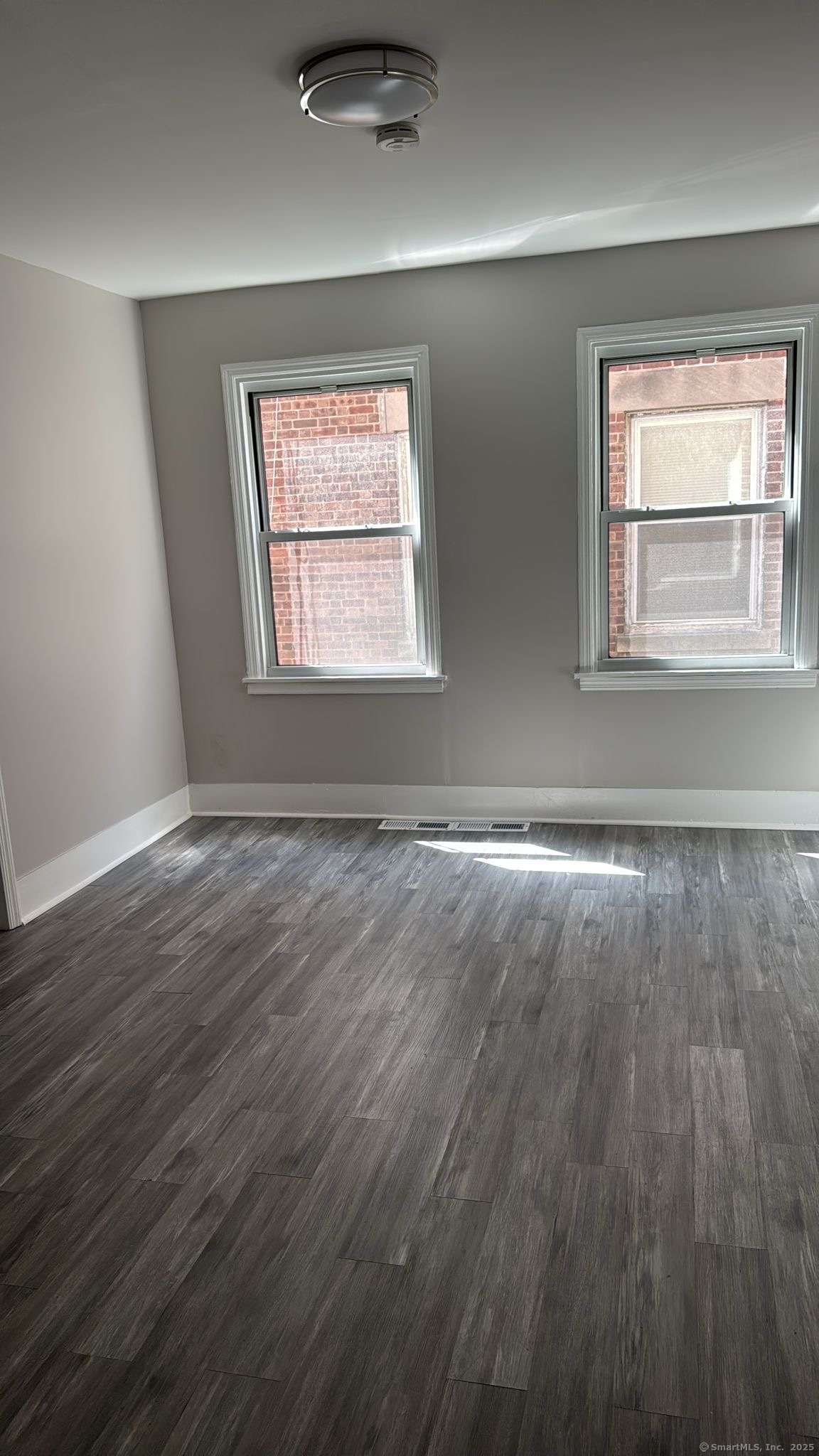 299 Dover Street, Unit 1 Bridgeport, CT 06610 - Photo 3 of 4 a view of an empty room with wooden floor and a window
