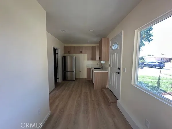 a view of a kitchen with wooden floor and a large window