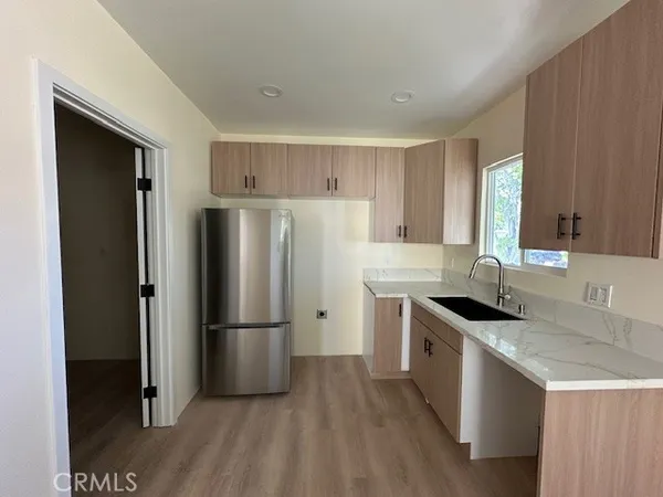 a kitchen with granite countertop a refrigerator and a sink