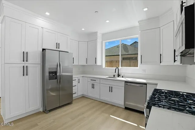a kitchen with stainless steel appliances granite countertop a sink stove and refrigerator
