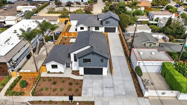 an aerial view of residential houses with outdoor space and parking