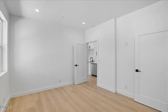 a large kitchen with stainless steel appliances granite countertop a refrigerator a sink a stove a microwave and white cabinets