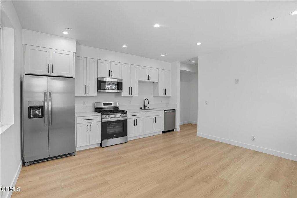 1907 Ocean Avenue Ventura, CA 93001 - Photo 33 of 51 a large kitchen with stainless steel appliances granite countertop a refrigerator a sink a stove a microwave and white cabinets