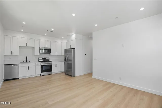 a kitchen with stainless steel appliances a refrigerator sink and microwave