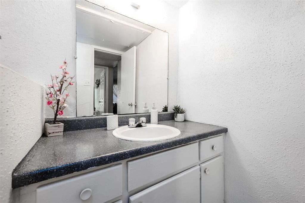4300 Shaver Street, Unit 11 Houston, TX 77034 - Photo 6 of 8 a bathroom with a granite countertop sink and a mirror
