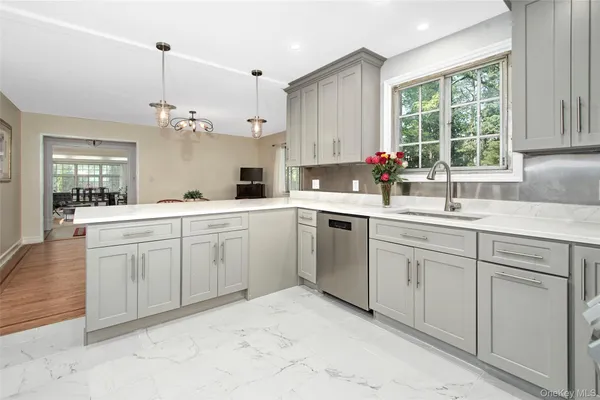 a dining room with kitchen island wooden floor and a view of kitchen