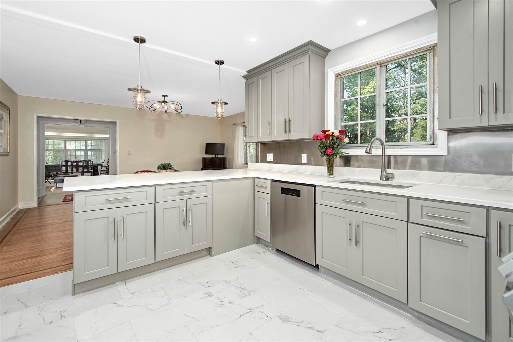2 Byworth Road New Rochelle, NY 10804 - Photo 13 of 31 Kitchen with gray cabinetry, stainless steel dishwasher, a peninsula, a sink, and light marble finish flooring
