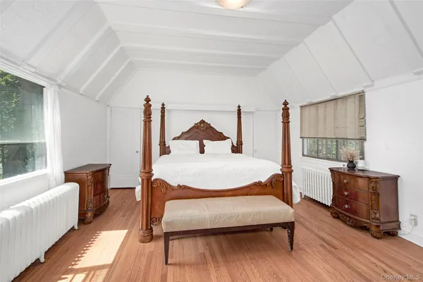 a bedroom with wooden floor bed and a window