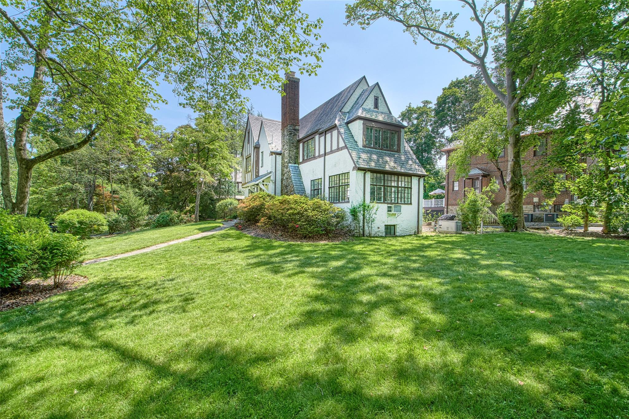 2 Byworth Road New Rochelle, NY 10804 - Photo 3 of 31 Rear view of house featuring a chimney, a lawn, and stucco siding