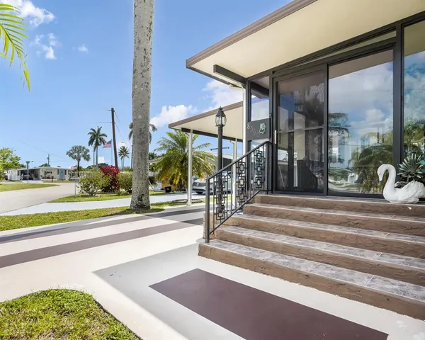 a living room with furniture large windows and wooden floor