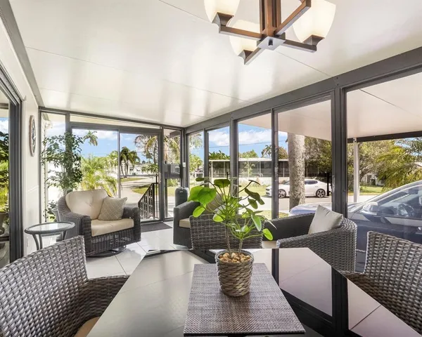 a view of a white house with a yard and potted plants