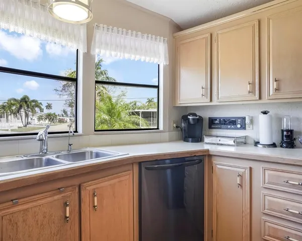 a view of a dining room and livingroom with furniture wooden floor a rug a fireplace and a painting