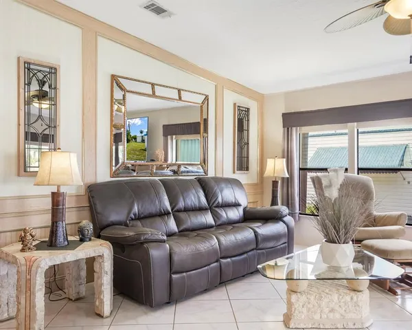 a living room with furniture chandelier and large windows
