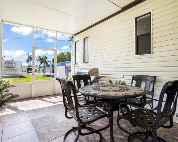 a roof deck with table and chairs and potted plants