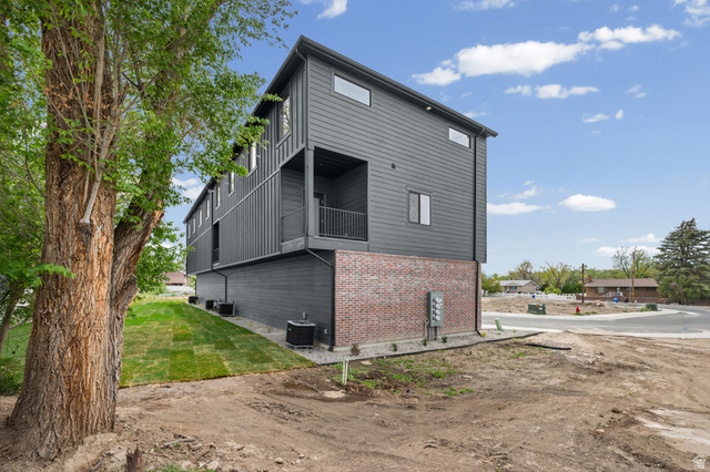 340 East 7635 S Street Sandy, UT 84047 - Photo 28 of 32 View of home's exterior featuring a yard, brick siding, and a balcony