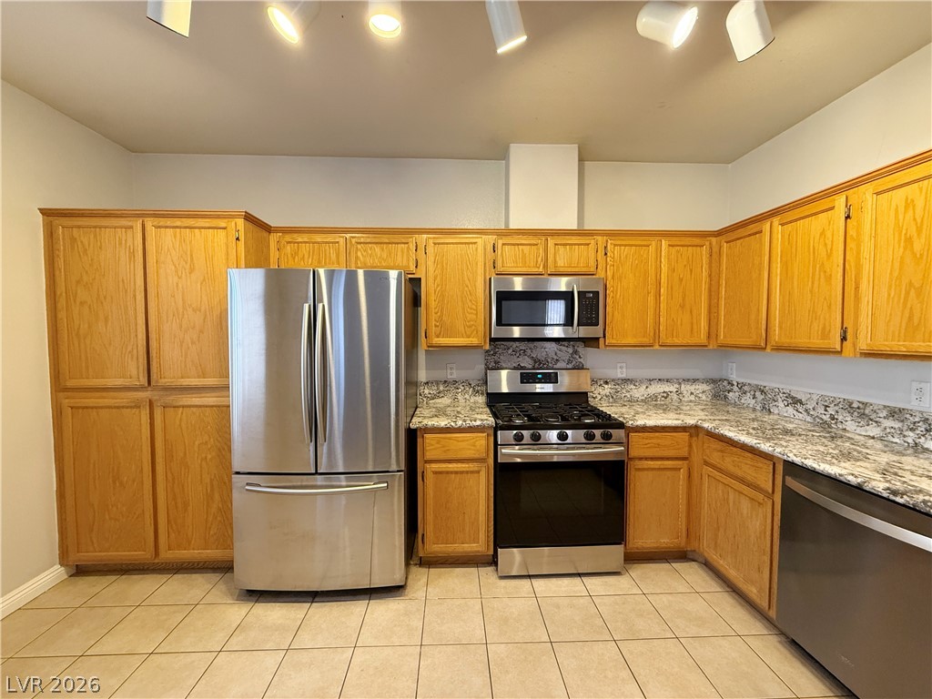 2185 Polynesia Circle Henderson, NV 89074 - Photo 14 of 37 The kitchen offers ample storage with light wood cabinetry, stone counters, and modern stainless steel appliances.