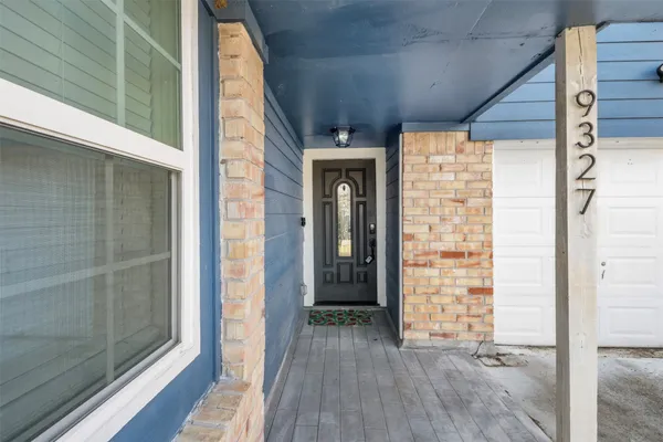 a view of outdoor space with wooden floor and a window