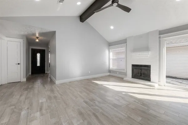 an empty room with wooden floor and fireplace