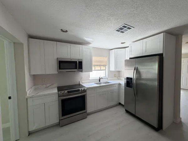 a kitchen with a refrigerator sink and stove top oven