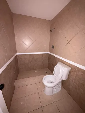 a bathroom with a toilet and a shower