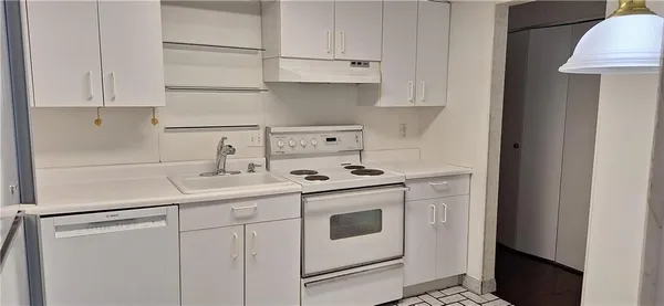 a white kitchen with sink and cabinets