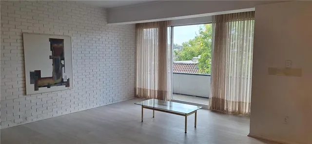 a view of a hallway with furniture and a window