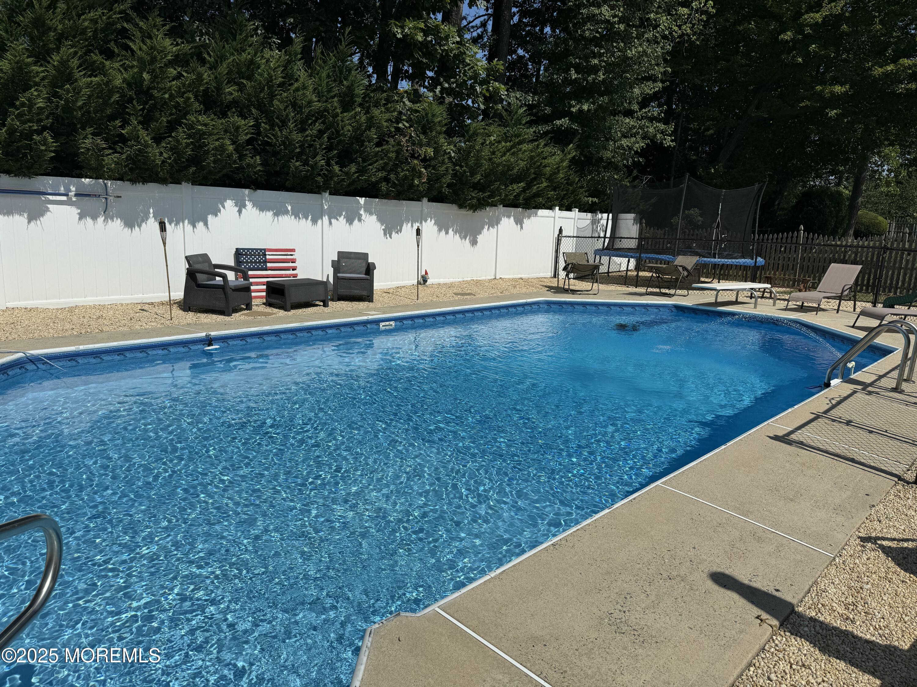 581 Winding River Road Brick, NJ 08724 - Photo 55 of 91 a view of a swimming pool with a chair and tables