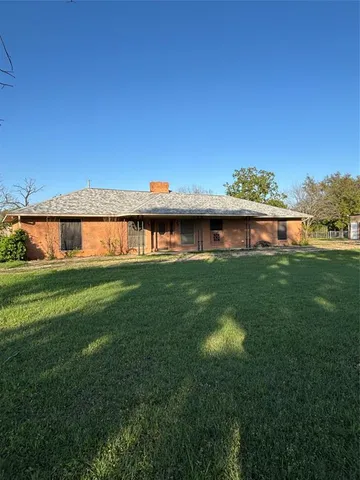 a view of a house with a yard from a lake