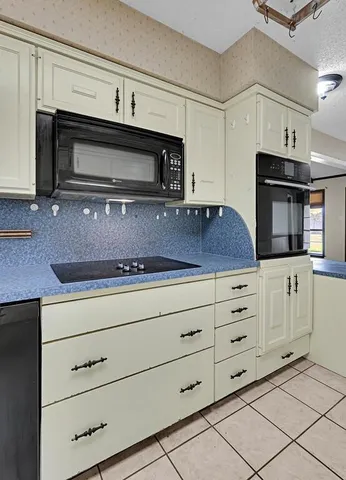 a kitchen with white cabinets and appliances