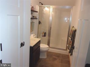 28880 Hudson Road Dagsboro, DE 19939 - Photo 20 of 29 a bathroom with a granite countertop shower a toilet and a sink
