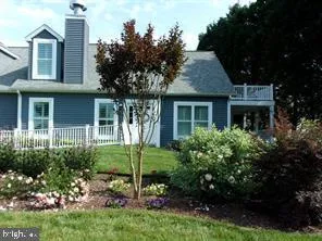 a view of house with a yard and plants