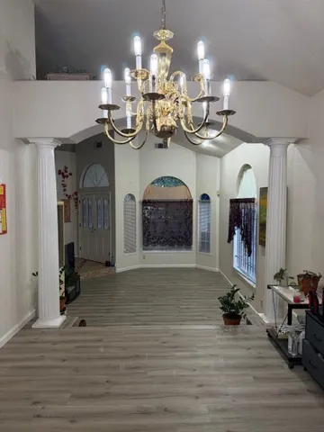 a view of a room with chandelier and wooden floor
