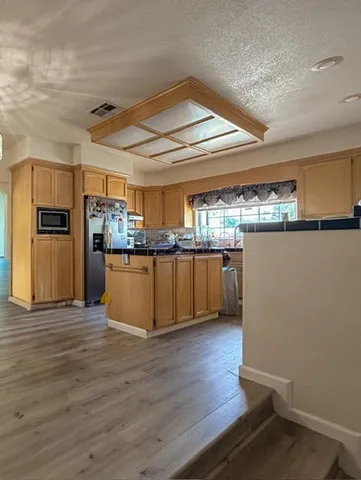 a view of a kitchen with wooden floor and electronic appliances