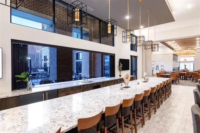 a living room with furniture kitchen view and a large window