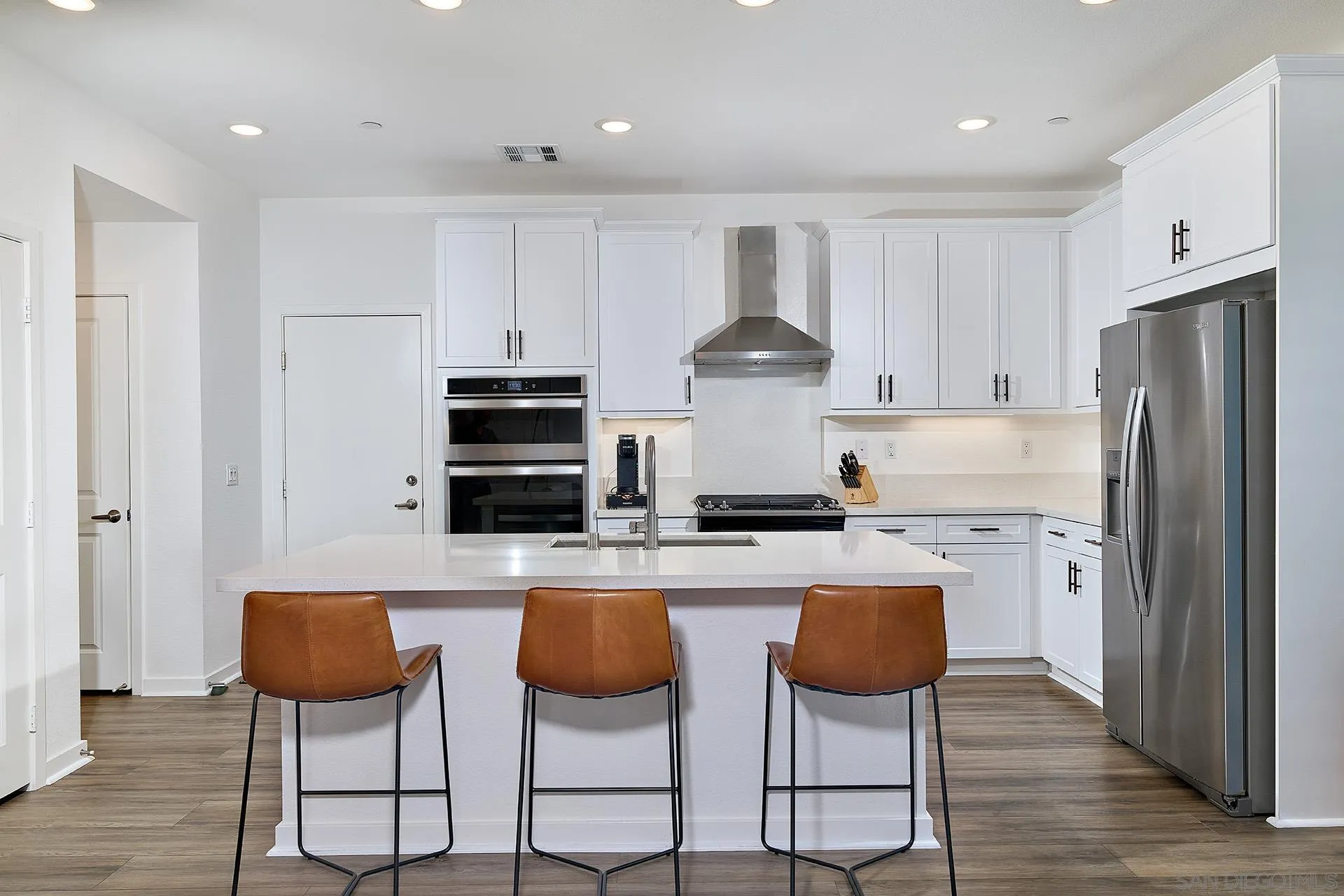 13070 Olympus Circle, Unit 1 Poway, CA 92064 - Photo 13 of 28 a kitchen with stainless steel appliances a stove a refrigerator and a stove with wooden floor