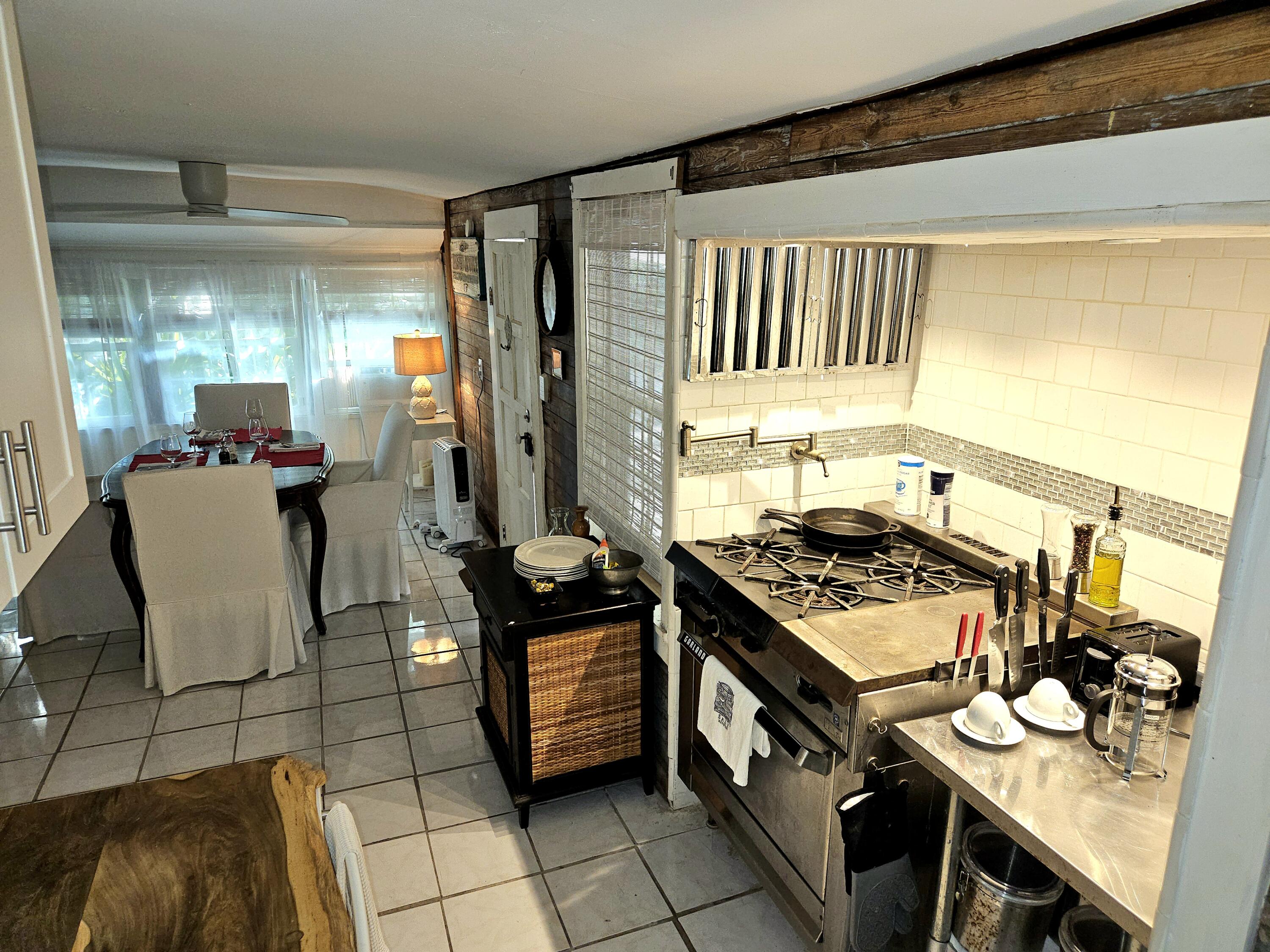 1015 Angela Street Key West, FL 33040 - Photo 24 of 42 a kitchen with a stove a sink and a dining table