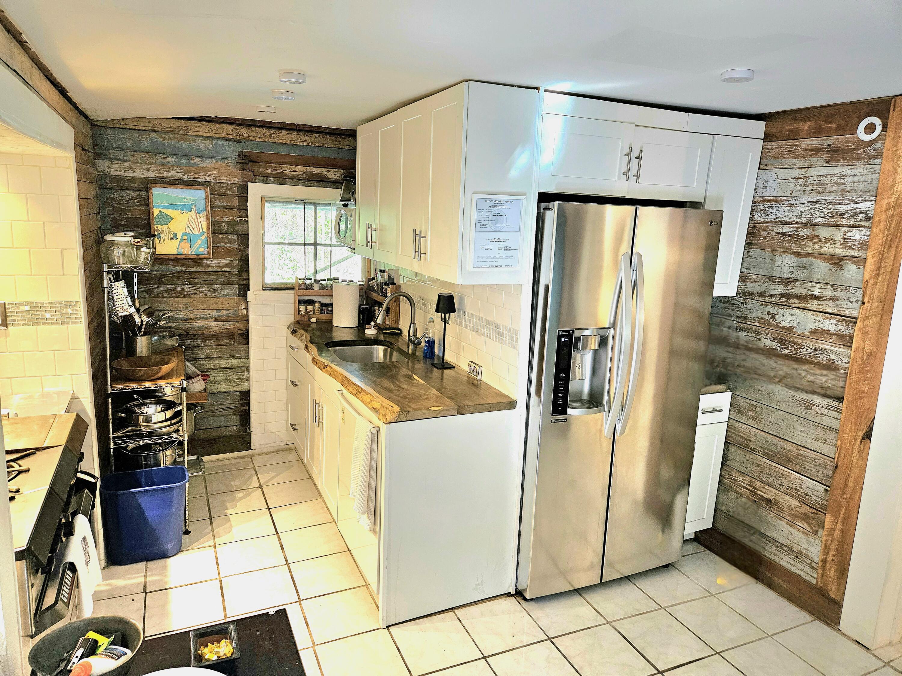 1015 Angela Street Key West, FL 33040 - Photo 25 of 42 a kitchen with a refrigerator a stove a washer dryer and cabinets