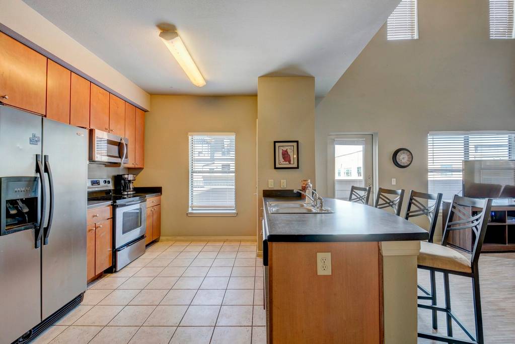 2515 Pearl Street, Unit 603 Austin, TX 78705 - Photo 7 of 15 a kitchen with stainless steel appliances granite countertop a sink stove and refrigerator