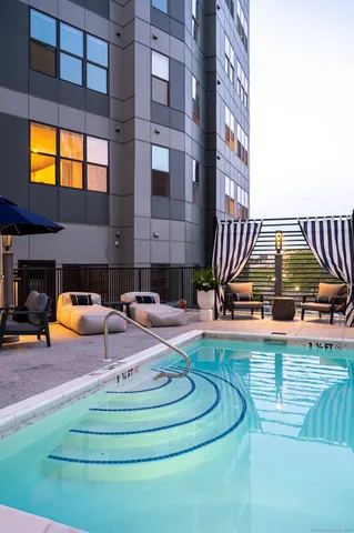 a view of pool with lawn chairs and a yard