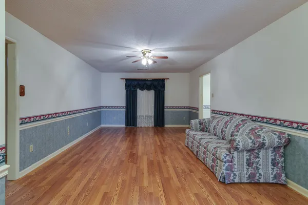 a living room with furniture and a wooden floor