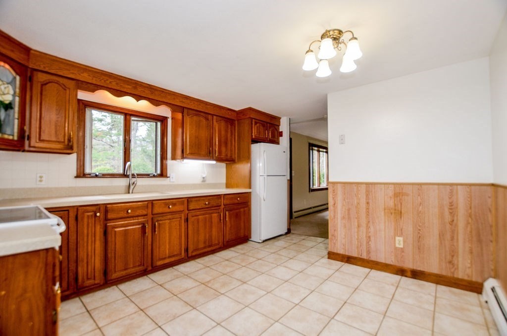 121 High Street Rochester, MA 02770 - Photo 13 of 33 a kitchen with stainless steel appliances granite countertop a refrigerator a sink dishwasher and wooden cabinets with wooden floor