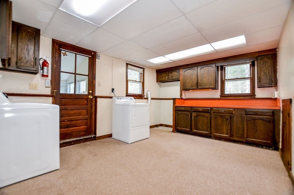 121 High Street Rochester, MA 02770 - Photo 24 of 33 a kitchen with stainless steel appliances kitchen island wooden cabinets a stove a sink and a large window