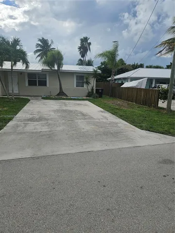 a front view of a house with a yard and potted plants